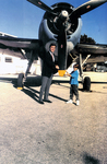 Jeb Bush and Son Standing Next to a Torpedo Bomber by Courtesy of the Naval Air Station Fort Lauderdale Museum